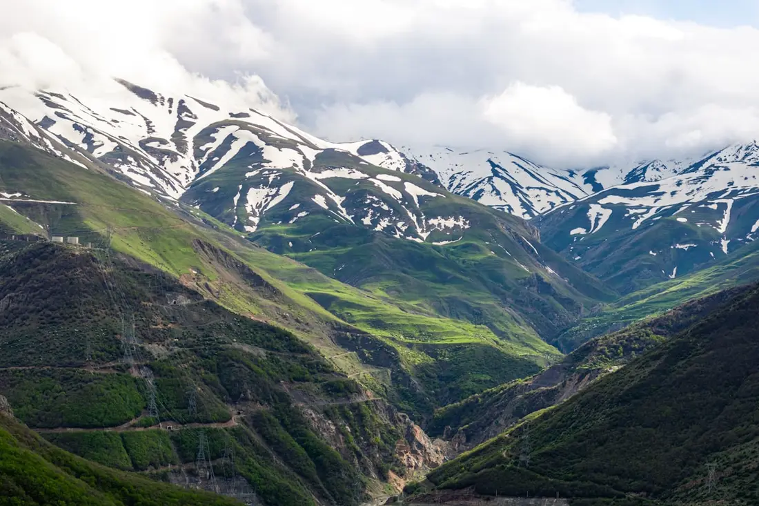 Snow still on the peaks above a valley that has already gone green